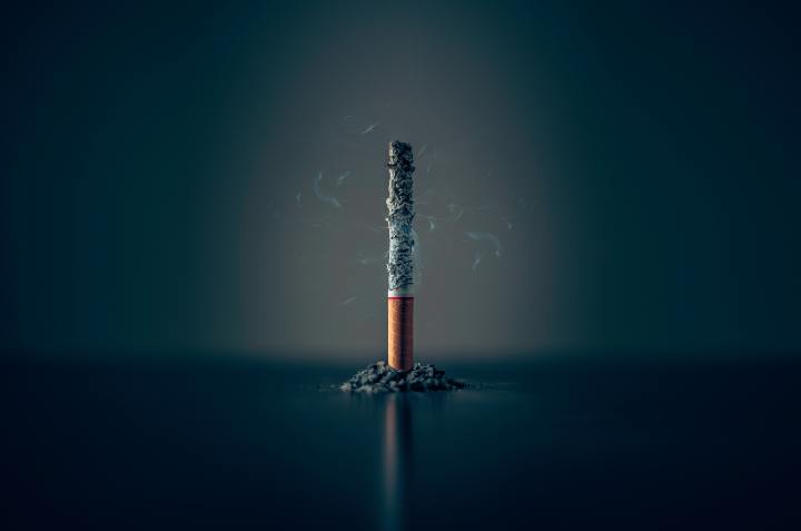 Single cigarette, standing vertically on a table
