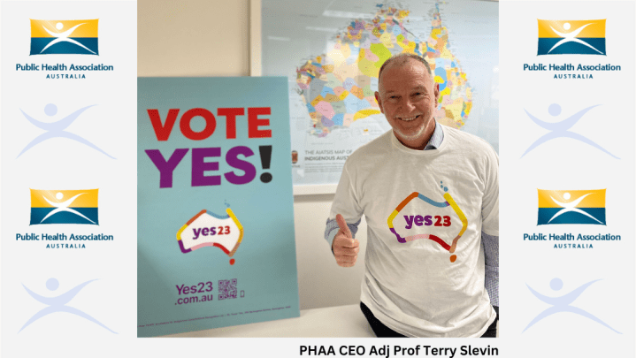 Terry Slevin wears a Yes T-shirt and gives the thumbs up. He is standing in front of a Vote Yes poster and a map showing Aboriginal and Torres Strait Islander language groups. The image has PHAA logos on both sides of its borders.