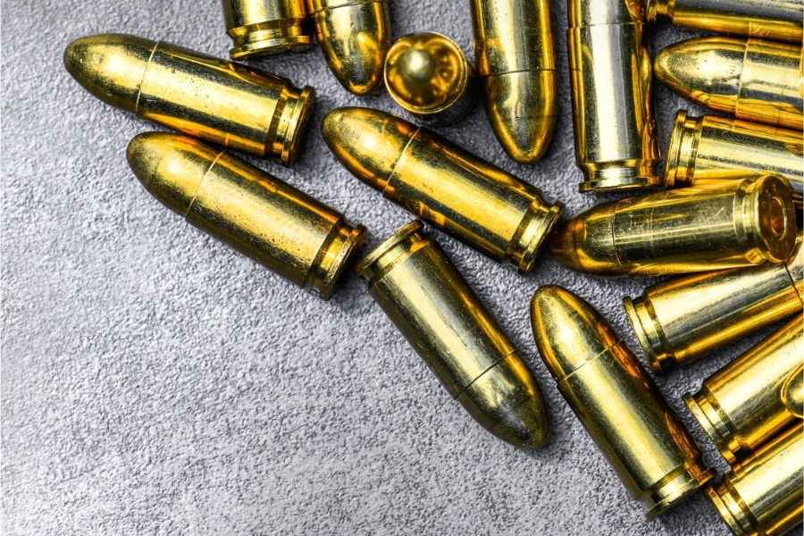 Golden bullets spread out on gray carpet.